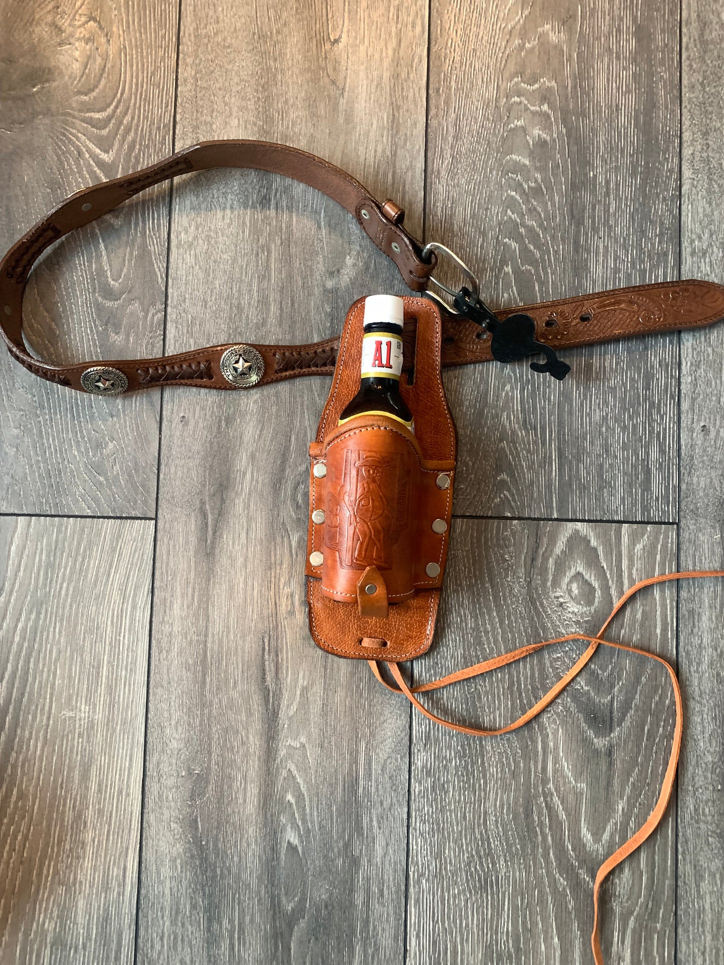 Leather Holder for Bottle Drinks

Tooled Leather Holder for Bottle Drinks. Attaches to your belt with slits...